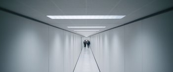 Movie still from “Severance” (2022), created by Dan Erickson – A group of people walking down a long hallway; Extreme Wide shot, High angle