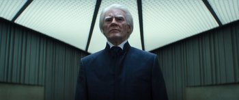 Movie still from “Severance” (2022), created by Dan Erickson – An older man wearing a suit and tie; Close Up shot, Low angle