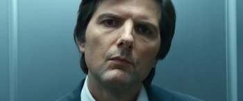 Movie still from “Severance” (2022), created by Dan Erickson – A person wearing a suit and tie; Close Up shot, Low angle