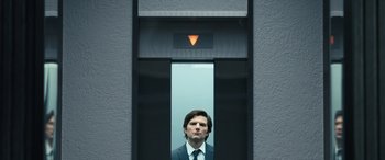 Movie still from “Severance” (2022), created by Dan Erickson – A man in a suit and tie in an elevator; Close Up shot, Low angle