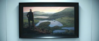 Movie still from “Severance” (2022), created by Dan Erickson – A man standing on top of a hill looking at a lake; Wide shot, High angle