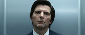 Movie still from “Severance” (2022), created by Dan Erickson – A person wearing a suit and tie; Close Up shot, Low angle