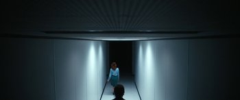 Movie still from “Severance” (2022), created by Dan Erickson – A woman walking down a long hallway in a building; Wide shot, Low angle