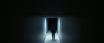 Movie still from “Severance” (2022), created by Dan Erickson – A man is standing in a dark hallway; Wide shot, Low angle