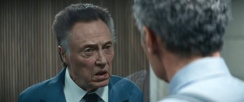 Movie still from “Severance” (2022), created by Dan Erickson – An older man is talking to a younger man in a suit; Close Up shot, Over the shoulder angle