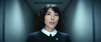 Movie still from “Severance” (2022), created by Dan Erickson – A woman in a white shirt and a black sweater; Close Up shot, Low angle