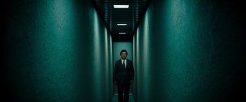 Movie still from “Severance” (2022), created by Dan Erickson – A man in a suit and tie standing in a hallway; Wide shot, Low angle
