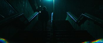Movie still from “Severance” (2022), created by Dan Erickson – A person walking down a set of stairs at night; Wide shot, Low angle