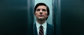 Movie still from “Severance” (2022), created by Dan Erickson – A man wearing a suit and tie looking into the distance; Close Up shot, Low angle