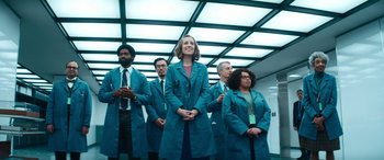 Movie still from “Severance” (2022), created by Dan Erickson – A group of people standing next to each other wearing lab coats; Medium shot, Low angle
