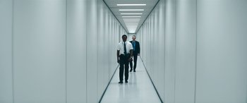 Movie still from “Severance” (2022), created by Dan Erickson – Two men are walking down a long hallway; Wide shot, Low angle