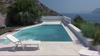 Movie still from “Sexy Beast” (2000), directed by Jonathan Glazer – An empty swimming pool sits on the edge of a cliff; Extreme Wide shot, High angle