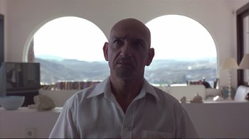 Movie still from “Sexy Beast” (2000), directed by Jonathan Glazer – A bald man in a white dress shirt; Close Up shot, Low angle