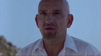 Movie still from “Sexy Beast” (2000), directed by Jonathan Glazer – A man with a bald head wearing a white shirt; Close Up shot, Over the shoulder angle