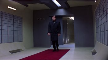 Movie still from “Sexy Beast” (2000), directed by Jonathan Glazer – A man in a black suit standing on a red carpet; Wide shot, Low angle
