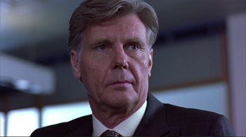 Movie still from “Sexy Beast” (2000), directed by Jonathan Glazer – An older man in a suit and tie looking into the distance; Close Up shot, Low angle