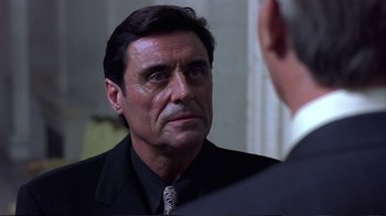 Movie still from “Sexy Beast” (2000), directed by Jonathan Glazer – A person wearing a suit and tie; Close Up shot, Over the shoulder angle