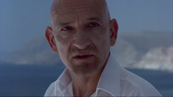 Movie still from “Sexy Beast” (2000), directed by Jonathan Glazer – A man with a bald head wearing a white shirt; Close Up shot, Low angle