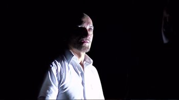 Movie still from “Sexy Beast” (2000), directed by Jonathan Glazer – A man in a white dress shirt is standing in the dark; Close Up shot, Low angle