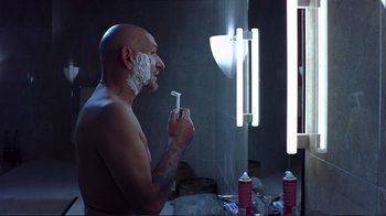 Movie still from “Sexy Beast” (2000), directed by Jonathan Glazer – A bald man is shaving in the bathroom; Close Up shot, Over the shoulder angle