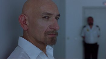 Movie still from “Sexy Beast” (2000), directed by Jonathan Glazer – A bald man with a beard is looking at the camera; Close Up shot, Over the shoulder angle