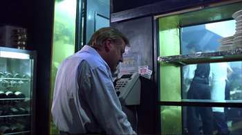 Movie still from “Sexy Beast” (2000), directed by Jonathan Glazer – A man on a payphone in front of a building; Medium shot, Low angle