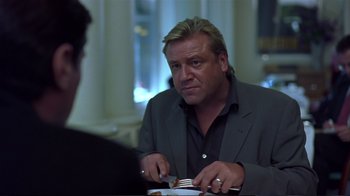 Movie still from “Sexy Beast” (2000), directed by Jonathan Glazer – A man sitting at a table with a plate in front of him; Close Up shot, Over the shoulder angle