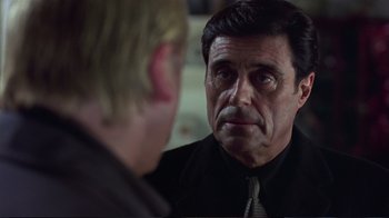 Movie still from “Sexy Beast” (2000), directed by Jonathan Glazer – A person looking at a person in a mirror; Close Up shot, Over the shoulder angle