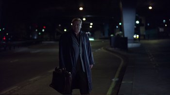 Movie still from “Sexy Beast” (2000), directed by Jonathan Glazer – A man in a long coat holding a briefcase in the dark; Wide shot, Low angle