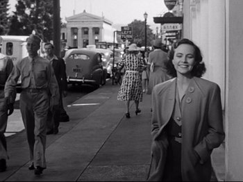 Movie still from “Shadow of a Doubt” (1943), directed by Alfred Hitchcock – An old black and white photo of women walking down a street; Medium shot, Low angle