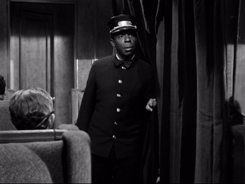 Movie still from “Shadow of a Doubt” (1943), directed by Alfred Hitchcock – A black and white photo of a man in a uniform; Medium shot, Low angle