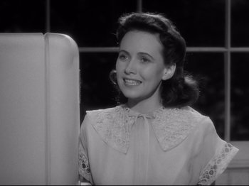 Movie still from “Shadow of a Doubt” (1943), directed by Alfred Hitchcock – A woman in a white dress smiling for the camera; Close Up shot, Low angle