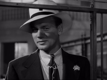 Movie still from “Shadow of a Doubt” (1943), directed by Alfred Hitchcock – A black and white photo of a man in a suit and hat; Close Up shot, Low angle