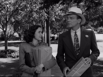 Movie still from “Shadow of a Doubt” (1943), directed by Alfred Hitchcock – A man and a woman standing next to each other; Medium shot, Low angle