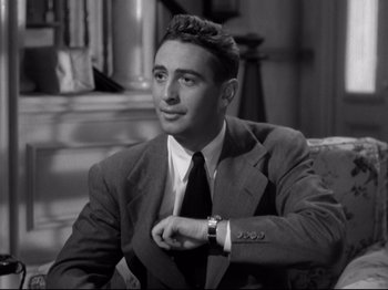 Movie still from “Shadow of a Doubt” (1943), directed by Alfred Hitchcock – Black and white photograph of a man wearing a suit and tie; Medium shot, Low angle