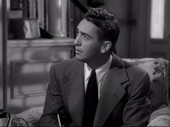 Movie still from “Shadow of a Doubt” (1943), directed by Alfred Hitchcock – A man in a suit sitting on a couch; Close Up shot, High angle