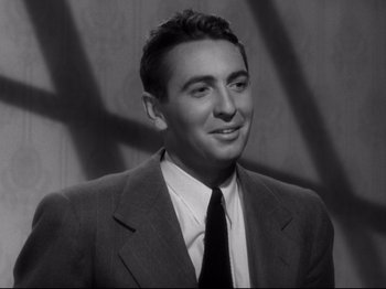 Movie still from “Shadow of a Doubt” (1943), directed by Alfred Hitchcock – Black and white photograph of a man wearing a suit and tie; Close Up shot, Low angle