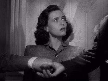 Movie still from “Shadow of a Doubt” (1943), directed by Alfred Hitchcock – An old photo of a woman holding hands with two men; Close Up shot, High angle