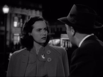 Movie still from “Shadow of a Doubt” (1943), directed by Alfred Hitchcock – An old photo of a man and a woman talking to each other; Close Up shot, High angle