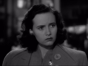 Movie still from “Shadow of a Doubt” (1943), directed by Alfred Hitchcock – A woman in a coat looking at the camera; Close Up shot, High angle