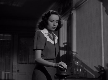 Movie still from “Shadow of a Doubt” (1943), directed by Alfred Hitchcock – A woman standing in front of an old fashioned coffee pot; Medium shot, Low angle