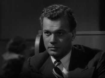 Movie still from “Shadow of a Doubt” (1943), directed by Alfred Hitchcock – Black and white photograph of a man wearing a suit and tie; Close Up shot, Low angle