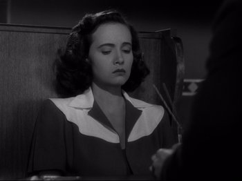 Movie still from “Shadow of a Doubt” (1943), directed by Alfred Hitchcock – A woman sitting in front of a mirror in a courtroom; Close Up shot, High angle