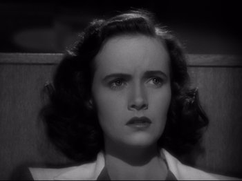 Movie still from “Shadow of a Doubt” (1943), directed by Alfred Hitchcock – A black - and - white photo of a woman in a white shirt; Close Up shot, High angle