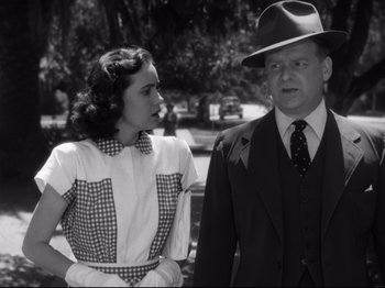 Movie still from “Shadow of a Doubt” (1943), directed by Alfred Hitchcock – An old photo of a man and a woman standing next to each other; Medium shot, Over the shoulder angle