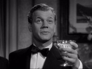 Movie still from “Shadow of a Doubt” (1943), directed by Alfred Hitchcock – A man in a tuxedo holding a glass of champagne; Close Up shot, Low angle