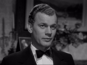 Movie still from “Shadow of a Doubt” (1943), directed by Alfred Hitchcock – A man in a suit and bow tie; Close Up shot, Low angle