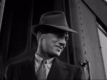Movie still from “Shadow of a Doubt” (1943), directed by Alfred Hitchcock – A black and white photo of a man in a suit and hat; Close Up shot, Low angle