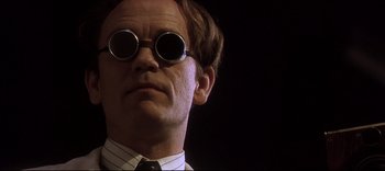 A person wearing round sunglasses
