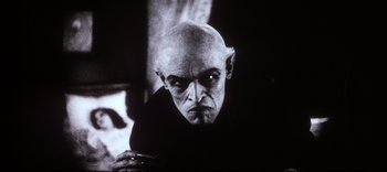 An older man with a bald head and a goatee looking at the camera